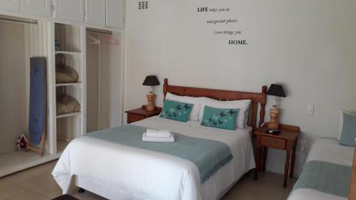 1 dormitorio con 1 cama grande con almohadas azules en Jacaranda Guesthouse, en Eshowe