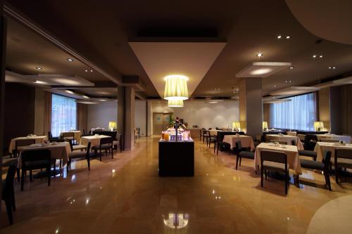 a dining room with tables and chairs and a chandelier at Attica 21 Barcelona Mar in Barcelona