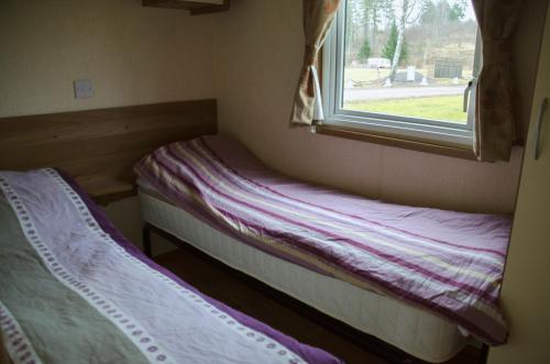 two beds in a small room with a window at Frykenbadens Camping & Resort in Kil