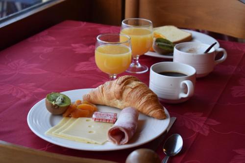 een tafel met een bord ontbijtproducten en jus d'orange bij Azureva La Clusaz les Confins in La Clusaz