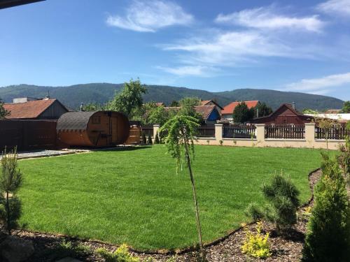 a yard with a green lawn with a building at Chata Eden in Hrabušice