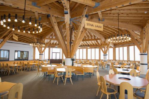 a dining hall with tables and chairs and chandeliers at Berghaus Nagens in Flims