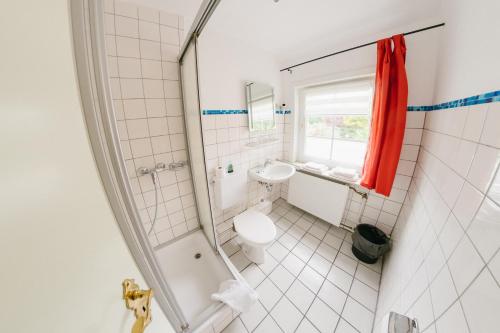 a bathroom with a shower and a toilet and a sink at Zum Eichenfrieden in Rade