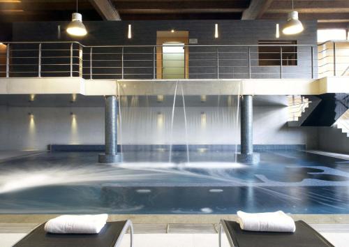 una gran piscina con una fuente de agua en Oca Vila de Allariz Hotel & Spa, en Allariz