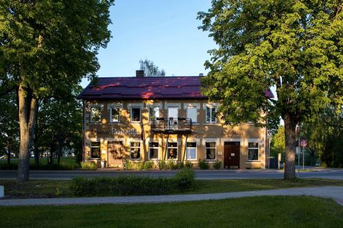 a large building with a balcony in front of it at Hotel Benevilla in Alūksne