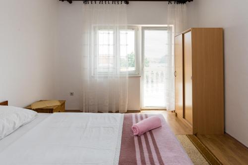 a bedroom with a bed with a pink towel on the floor at Apartments G&M in Vodice