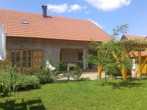 una casa con techo naranja y patio en Latin, en Plaški