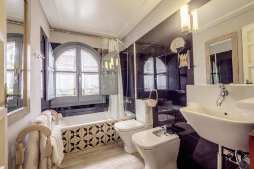 un bagno con lavandino, WC e vasca di ApartaSuites Alberca Deluxe a Cordoba