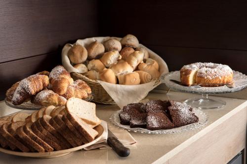 a table with different types of bread and pastries at Smart Hotel Holiday in Mestre
