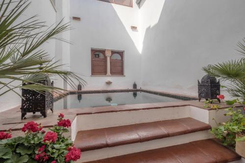 una piscina en una casa con flores en ApartaSuites Alberca Deluxe, en Córdoba