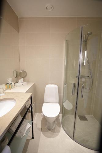 a bathroom with a toilet and a glass shower at Elite Stadshotellet Växjö in Växjö