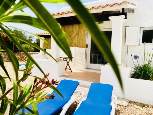 卡拉紹納海灘的住宿－Can Chumbera Formentera，房子的庭院里摆放着一双蓝色的椅子