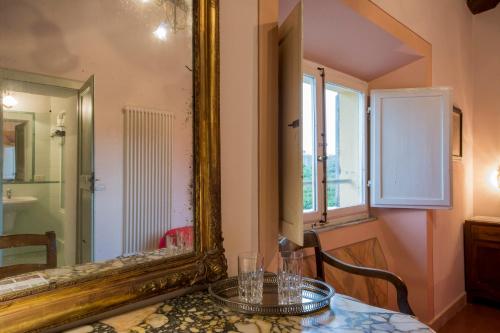 una mesa con espejo y una mesa con gafas. en Residenza alla Lizza, en Siena