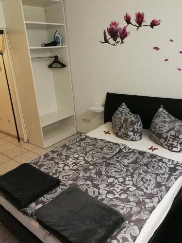 ein Bett mit einer schwarzen und weißen Bettdecke und Kissen in der Unterkunft 1 Zimmer Apartment KLEIN aber FEIN in Fürth