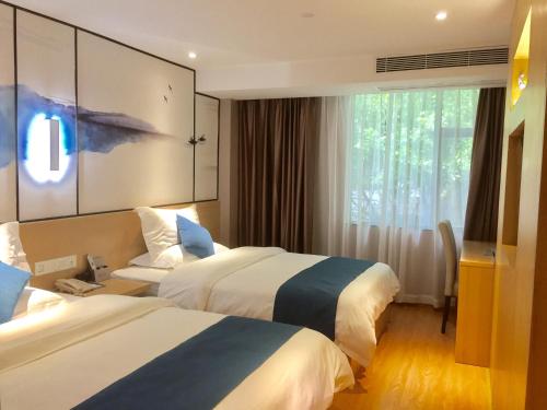Habitación de hotel con 2 camas y ventana en Guangzhou Hongcheng Hotel en Cantón