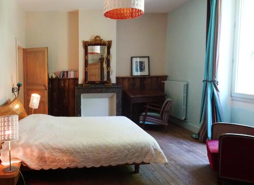 una camera con letto, scrivania e specchio di Les Trois Hiboux a Crespin