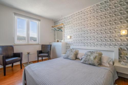 um quarto com uma cama e 2 cadeiras em Villa Jidro em Trogir