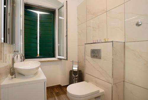 een badkamer met een toilet, een wastafel en een douche bij Studio Apartman Fictilis in Split