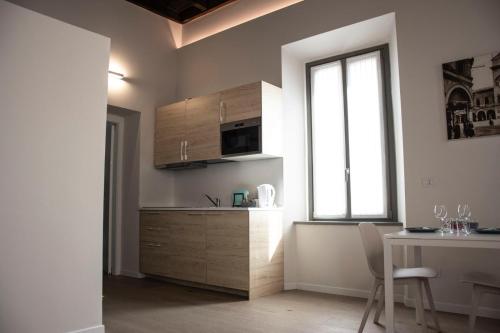 a kitchen with a table and a microwave and a window at Residenza La Torre in Mantova