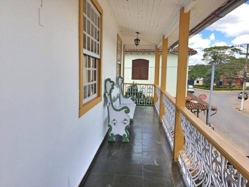 a balcony of a house with a bench on it at Pousada o Amanhecer in Tiradentes