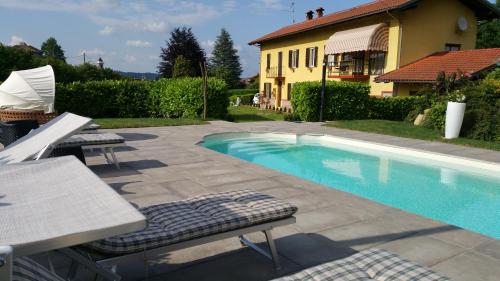 a swimming pool with a table and chairs next to a house at Bed & Bistrò Che Piasì in Calamandrana