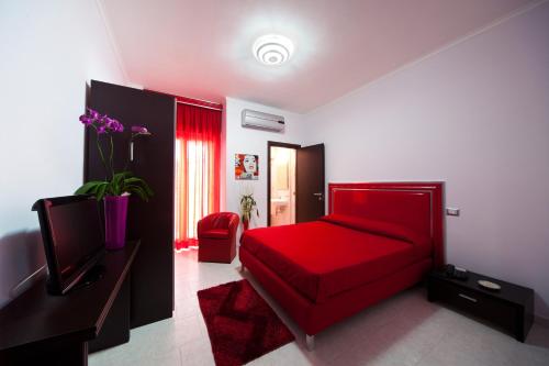 1 dormitorio con cama roja y sofá rojo en Hotel Glamour, en Qualiano