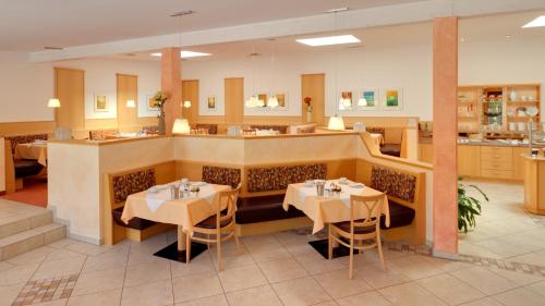 a dining room with two tables and a bar at Hotel Bergfried & Schönblick in Bad Reichenhall