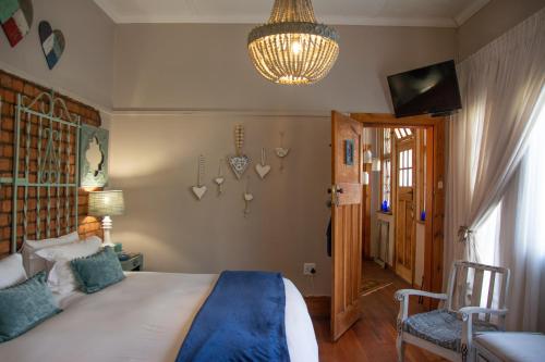 a bedroom with a large bed and a chandelier at Mirabel Guesthouse in Parys