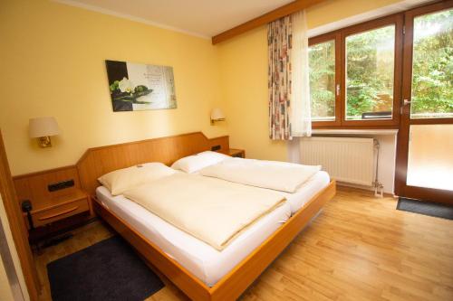 ein Schlafzimmer mit einem großen Bett in einem Zimmer in der Unterkunft Hotel am Wald in Ottobrunn