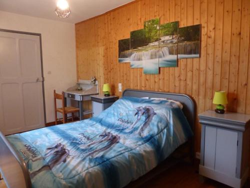 a bedroom with a bed with a blue blanket on it at Appartement La Tour in Embrun