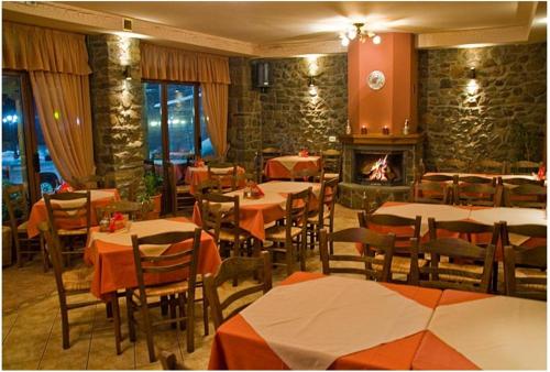 a restaurant with tables and chairs and a fireplace at To Spiti tis Pareas in Áyios Nikólaos