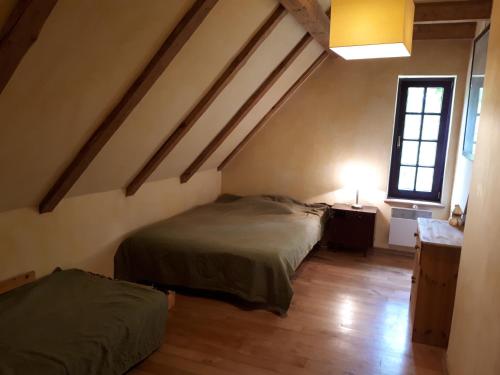 a attic room with two beds and a window at Dom koło Rewala in Paprotno