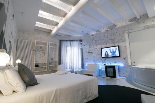 a bedroom with a white bed and a tv on the wall at Design&Art Pie' - Spa & Comfort Guesthouse in Rome
