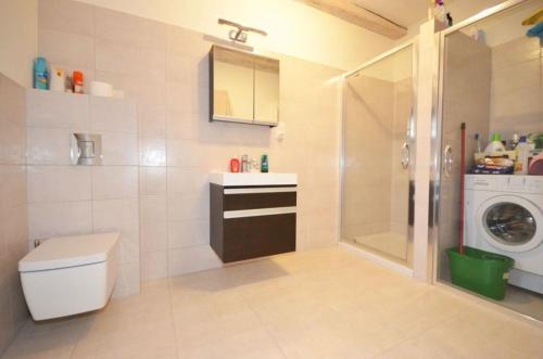 a bathroom with a sink and a washing machine at Dom koło Rewala in Paprotno