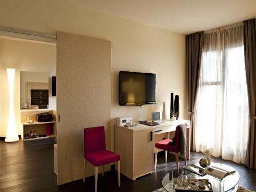 a hotel room with a desk and red chairs at Art Hotel Museo in Prato