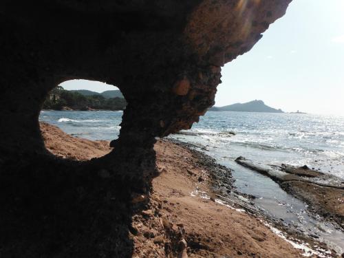 a view of the beach through a hole in the rock at Résidence L'éléphant in Saint-Raphaël