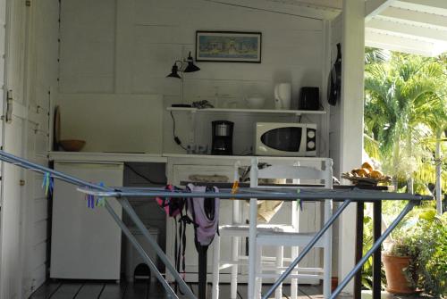 eine Küche mit einer Theke und einem Tisch in der Unterkunft La Case Dentelle in Le Diamant