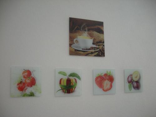 a wall with pictures of fruit and a cup of coffee at B&B Il Crocevia in Teglio