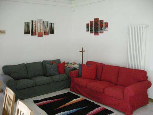 a living room with two couches and a cross on the wall at B&B Il Crocevia in Teglio