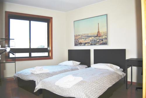 two beds in a room with a view of the eiffel tower at Parque Nacoes Prime Apartments 16 - 3 quartos in Lisbon