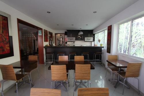 een eetkamer met tafels en stoelen en een bar bij Hotel Chicama in Trujillo