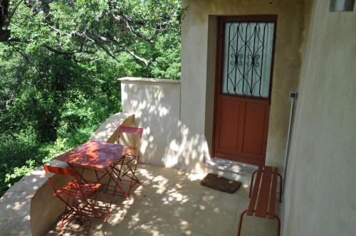 a porch with two chairs and a door at Le Jas Du Colombier in Moustiers-Sainte-Marie