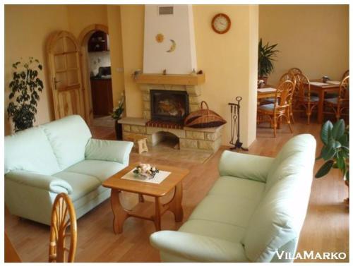 sala de estar con sofás, mesa y chimenea en Vila Marko, en Nová Lesná