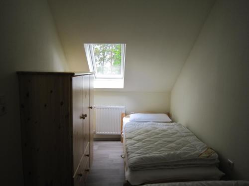 a small room with a bed and a window at Ferienwohnung Friesenstall in Heede