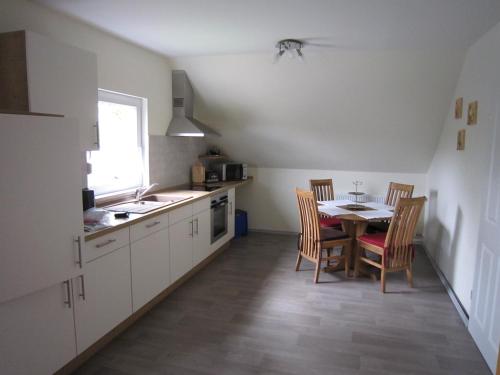 a kitchen with a table and chairs and a dining room at Ferienwohnung Friesenstall in Heede