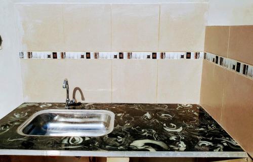 a kitchen with a sink with a black counter top at Raíces Federaenses Monoambientes in Federación