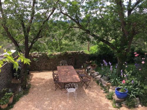 a table and chairs in a garden with flowers at Fort de la Bastide in Uzer