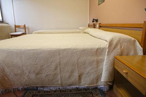 a bedroom with two beds and a dresser at Albergo Gusmeroli in Tirano