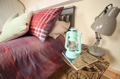 eine Lampe auf einem Tisch neben einem Bett in der Unterkunft McHugh's Loft in Rathmullan