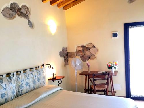 a bedroom with a bed and a table and a tableablish at Affittacamere Anselmi Sauro in Portoferraio
